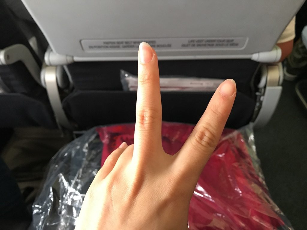 機内でピースサイン